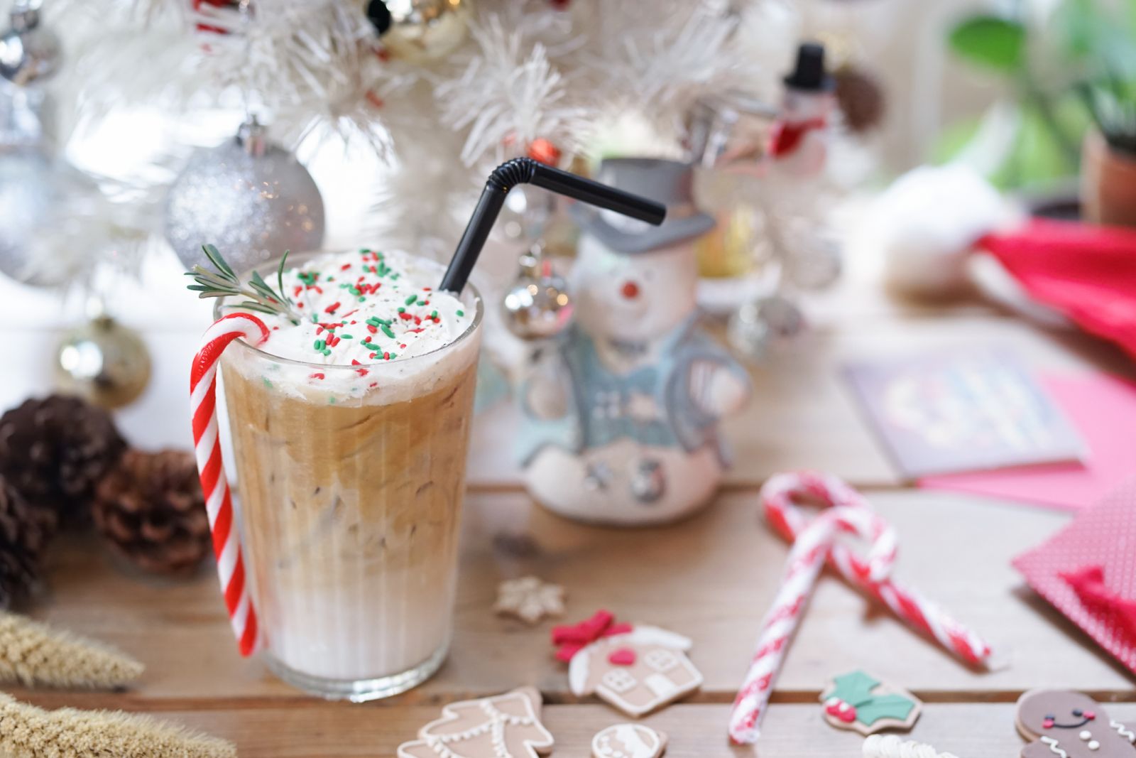 Holiday themed Iced coffee in front of a white Christmas tree
